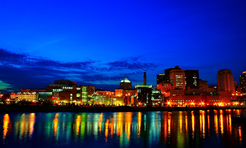 Downtown Saint Paul at dusk along the Mississippi River from Harriet Island. Photo by Tony Webster. CC BY 2.0